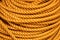 Yellow rope pile closeup photo. Ship or rock climbing tackle. Natural material woven cordage. Simple rope bulk concept