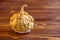 Yellow rotten pumpkin with warts on brown wooden background