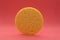 Yellow round make-up sponge on a pink gradient background