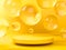 Yellow round stage, pedestal or podium and water and glass bubbles or spheres in yellow studio. 3d render. Background or