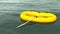 Yellow rubber boat swimming lonely on a vast green ocean