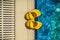 Yellow rubber children`s slippers on the edge of the pool as an abstract background. Rubber shoes are necessary near the pool for