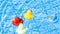 Yellow rubber duck. Funny kids inflatable red, blue and white toy float in water of summer pool. Funny bird toy for kids