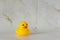 Yellow rubber duck for swimming on a marble background.