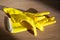 Yellow rubber gloves for housework lie on a wooden surface on a sunny day. Closeup view