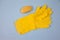 Yellow rubber gloves and Yellow soap lie on a blue background. Purity. Hygiene. Protection. topview