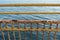 Yellow rusted fence and sea in background