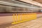 Yellow safety barrier on platform of subway as blurred image of