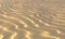 Yellow sand on beach with waves under evening sun light closeup