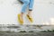 Yellow Sandals. Woman Wearing Flip Flops and Blue Jeans Standing on Old Cement Floor