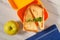 Yellow sandwich box with toasted slices of bread, cheese and gre