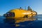 Yellow scientific submarine exterior with lights illuminating underwater. Generative AI