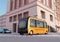 Yellow self-driving shuttle bus is driving through an intersection