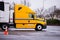 Yellow semi trucks reefer trailer on parking warehouse