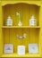 Yellow shabby chic interior design display. Dresser shelf ornaments.