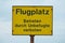 Yellow sign with the inscription: Airfield, forbidden to enter by unauthorized persons, in German language