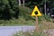 Yellow sign with kettle or teapot on the side of the road.