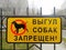 Yellow sign on metal fence with dog icon and a red round badge with a crossed out line and the inscription in Russian