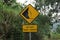Yellow sign with a natural background. Hati-hati tanah longsor means beware of landslides