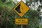 Yellow sign with a natural background. Hati-hati tanah longsor means beware of landslides