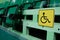Yellow sign is a place for disabled people in the gym among the seats for spectators. Auditorium with rows of raised green chairs