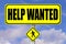 Yellow signboard with the words Help Wanted written