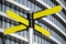 Yellow signpost with four arrows, office building in background