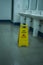 Yellow slippery warning sign, caution wet floor sign in the toilet room