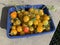 Yellow small tomatoes and cucamelon freshly picked in blue plastic punnet