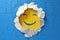 A yellow smiley face with hole through paper, concept of Happy expression