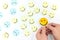 A yellow smiling face icon among a group of sad and happy face emoticons. Positivity, attraction and happiness.