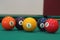 Yellow snooker ball with number one on it with other colorful balls placed in a row on a table