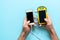 Yellow solar power battery of a device on a blue background in the hands of a man.