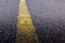 Yellow solid line, grunge single road marking on asphalt, background with copy space