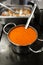 Yellow soup in a metal pot. Preparing lunch in the dining room. Exotic stew. Food in a steel metal dish