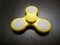 Yellow spinner toy at dark wooden board