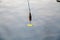 Yellow spinning spoon above surface of water