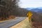 Yellow Spiral Curve Sign Along a Mountain Roadway