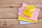 Yellow sponge on wooden table with color cloths, top view