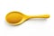 A yellow spoon filled with uniform yellow spheres on a white background
