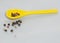 Yellow spoon whit pepper on a neutral background