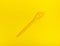 Yellow spoon on yellow background