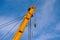 Yellow steel floating crane boom closeup. blue sky and white clouds