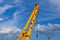 Yellow steel floating crane boom detail. blue sky and white clouds