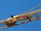 yellow steel truss crane boom detail under blue sky