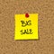 Yellow stick note paper with words BIG SALE pinned on cork board