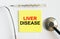 Yellow sticker with the text Liver Disease. A thermometer with a phonendoscope on a white background