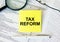 Yellow sticker with text Tax Reform on financial docs