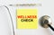 Yellow sticker with the text Wellness Check. A thermometer with a phonendoscope on a white background