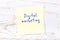 Yellow sticky note with handwritten text digital marketing